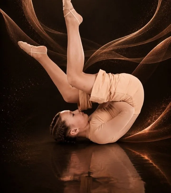 Dancer moving against a charcoal background with rose-gold waves